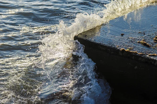 Zee golven strijden tegen de grote rotsen aan de kust. — Stockfoto