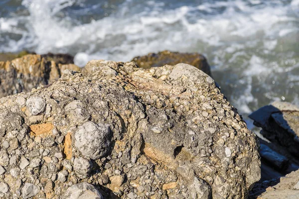 Zee golven strijden tegen de grote rotsen aan de kust. — Stockfoto