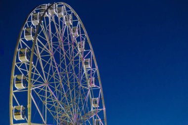 Mavi gökyüzüne karşı çok büyük dönme dolap.