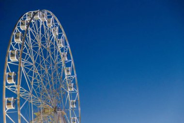 Mavi gökyüzüne karşı çok büyük dönme dolap.