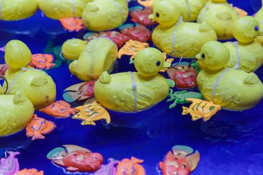 Sarı oyuncak lastik ördek ailesi suda yüzen.