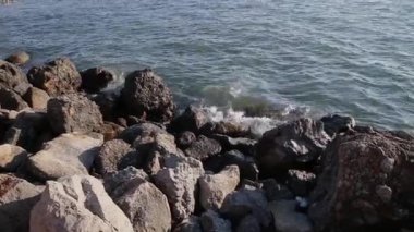 Dalgalar deniz kıyısında kayalar karşı mücadele ediyoruz.
