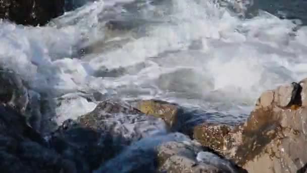 Meereswellen kämpfen gegen die Felsen am Ufer. — Stockvideo