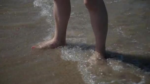 Beine im Meerwasser, mit einem Zustrom von Wellen. — Stockvideo