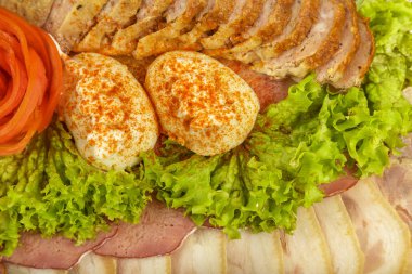 Verdure ile dekore edilmiş bir ayna yemek üzerine dilimlenmiş et.