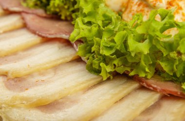 Verdure ile dekore edilmiş bir ayna yemek üzerine dilimlenmiş et.