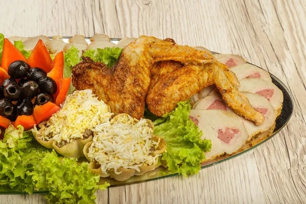 Piring dari tartlet dan sayap ayam dengan adanya daun selada . — Stok Foto