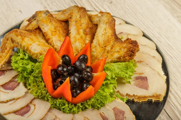 Piring dari tartlet sayap ayam dan daging diiris dengan adanya daun selada . — Stok Foto