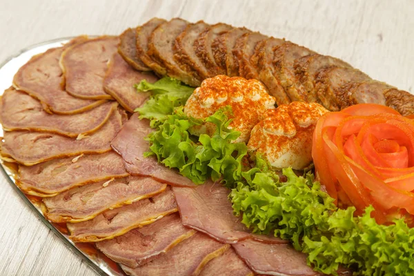 Kött skuret på en spegel maträtt dekorerad med verdure. — Stockfoto