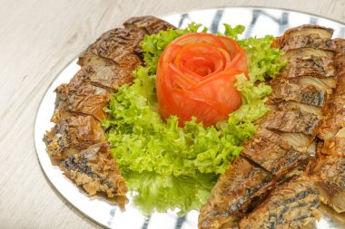 Ringa balığı otlar ile bir tabağa dilimlenmiş.