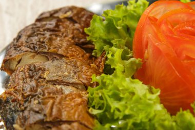 Ringa balığı otlar ile bir tabağa dilimlenmiş.