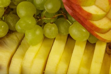 Çok güzel ve sanatsal dilimlenmiş meyve bir tepside.