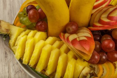 Çok güzel ve sanatsal dilimlenmiş meyve bir tepside.