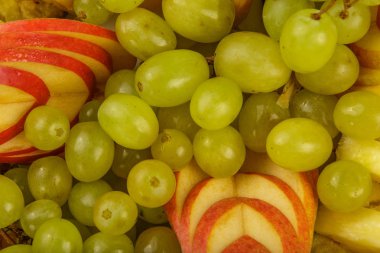 Çok güzel ve sanatsal dilimlenmiş meyve bir tepside.