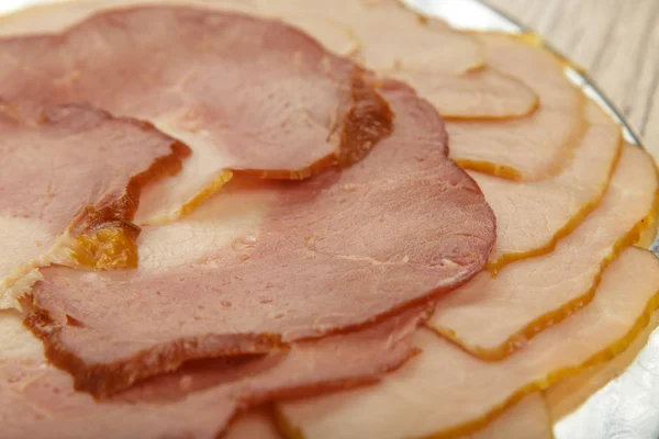 Cortes de salchichas de diferentes variedades en un plato . — Foto de Stock