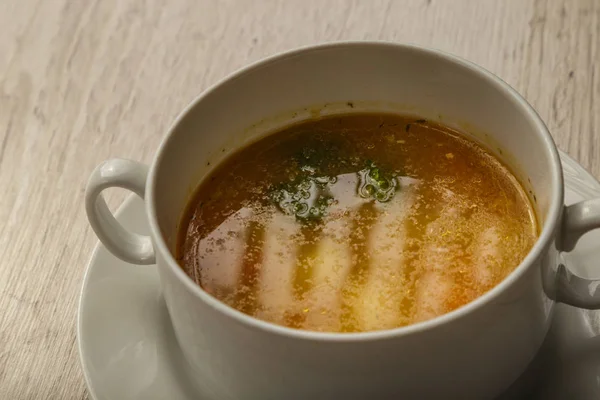 Placa con sopa en un plato blanco sobre un fondo de madera . — Foto de Stock