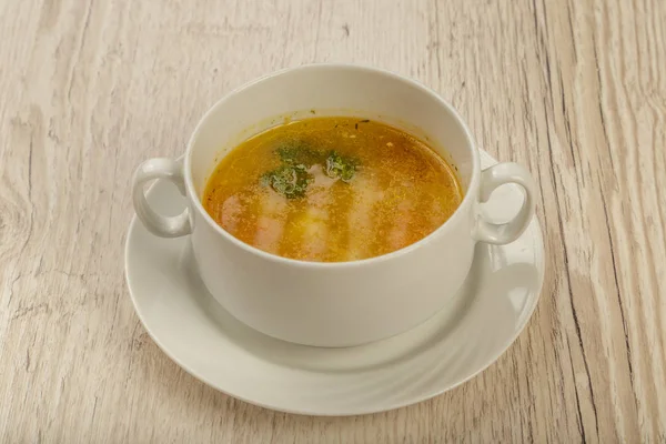 Placa con sopa en un plato blanco sobre un fondo de madera . — Foto de Stock