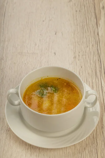 Placa con sopa en un plato blanco sobre un fondo de madera . — Foto de Stock