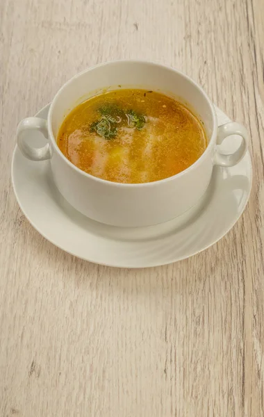 Placa con sopa en un plato blanco sobre un fondo de madera . — Foto de Stock