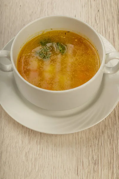 Placa con sopa en un plato blanco sobre un fondo de madera . — Foto de Stock