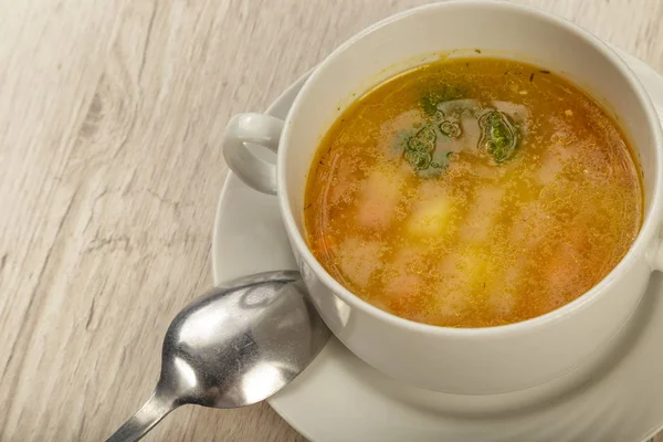 Placa con sopa y cubiertos sobre fondo de madera . — Foto de Stock