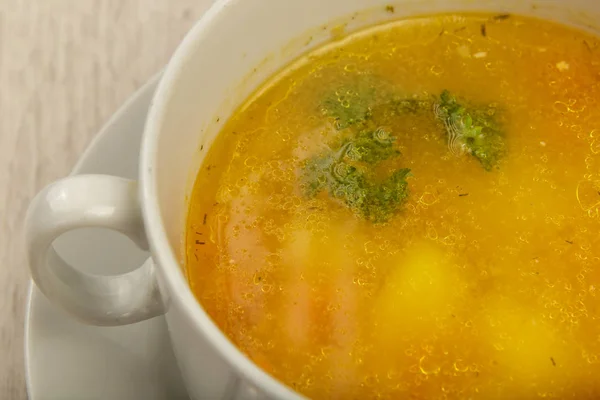 Placa con sopa en un plato blanco sobre un fondo de madera . — Foto de Stock