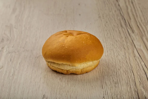 Fresh ruddy bun on a wooden background. — Stock Photo, Image