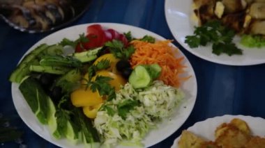 Tablo ve farklı et yemekleri bir tabağa otlar ile salata.