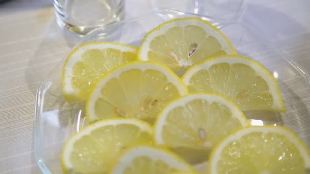 Gesneden citroenen op een glasplaat close-up. — Stockvideo