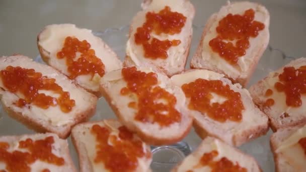 Deliciosos sándwiches con caviar rojo en un buffet o banquete, primer plano . — Vídeo de stock