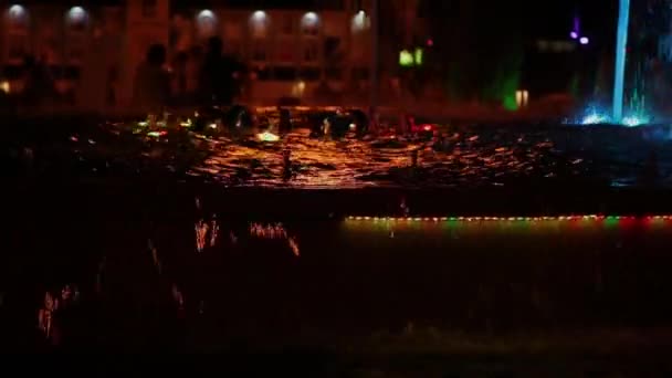 五颜六色的音乐喷泉在晚上, 在不同的颜色闪闪发光. — 图库视频影像