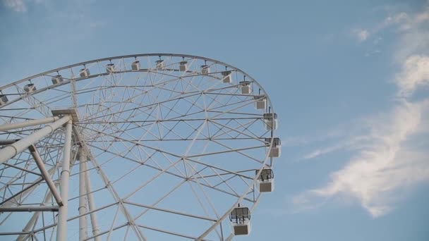 Rueda de la fortuna contra el cielo azul en el parque de atracciones . — Vídeo de stock