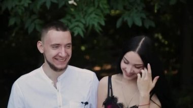 İki sevgili bir bankta oturup ve birbirlerine gülümse.