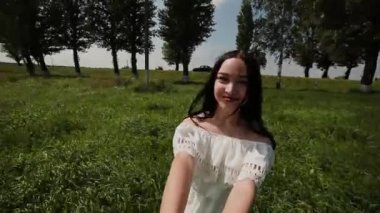 Kız sevgili ellerini tutar ve onu birlikte yeşil sahada fırtınası.