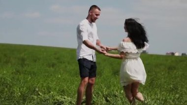 Sevgi dolu çift eğleniyor sahada güneşli bir günde.