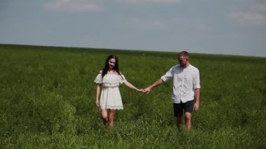 Sevgi dolu çift eğleniyor sahada güneşli bir günde.