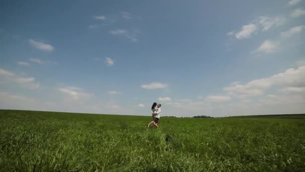 Loving couple having fun on the field on a sunny day. — Stock Video