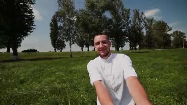 Een man houdt handen met zijn geliefde en wervelingen samen met haar op het groene veld. — Stockvideo