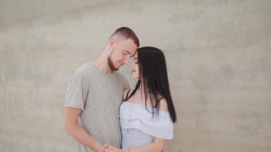 Sevgi dolu birkaç hugs ve öper bir beton duvar arka planı.