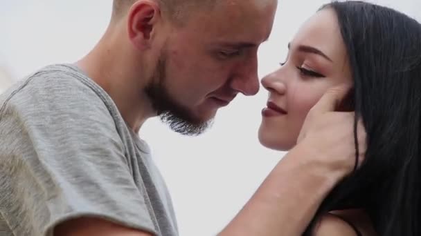 Um casal amoroso está de pé sob uma ponte abraçando e beijando . — Vídeo de Stock