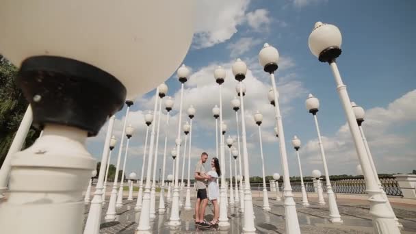 Egy szerető pár ölelést, és az embankment közelében az utcai lámpák csók. — Stock videók