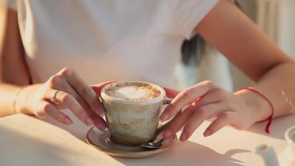 Cappuccino i händerna på en vacker flicka. — Stockvideo