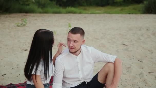 爱的情侣坐在沙滩上拥抱, 日落. — 图库视频影像