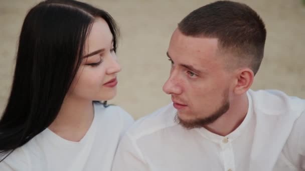 Verliefde paar zittend op het strand en knuffelen, zonsondergang. — Stockvideo