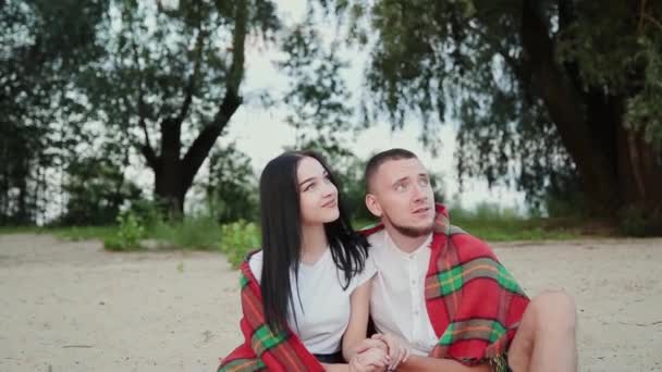 Amante casal sentado na praia e abraçando, pôr do sol . — Vídeo de Stock