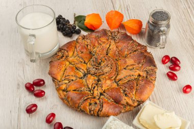 Ahşap arka plan ve malzemeler üzerinde haşhaş tohumu ile pasta.