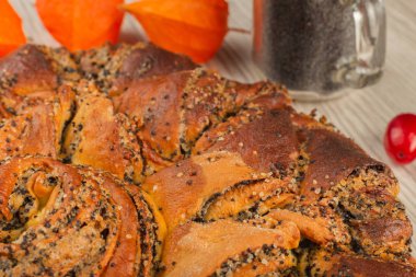 Ahşap arka plan ve malzemeler üzerinde haşhaş tohumu ile pasta.