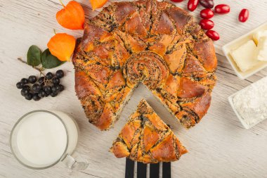 Ahşap arka plan ve malzemeler üzerinde haşhaş tohumu ile pasta.