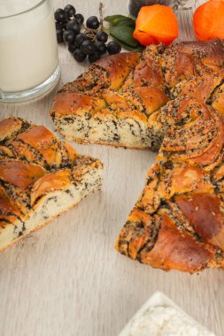 Ahşap arka plan ve malzemeler üzerinde haşhaş tohumu ile pasta.