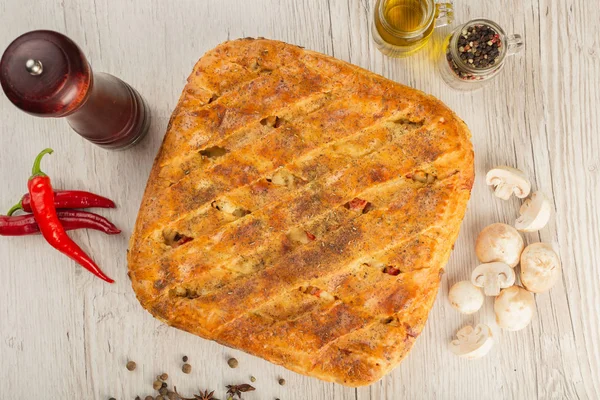 Meat pie on a wooden background with ingredients. — Stock Photo, Image